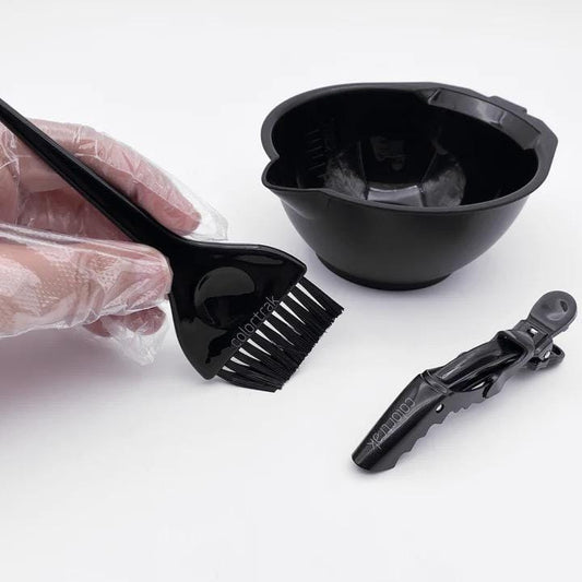 A hair coloring kit including a black brush comb, a black mixing bowl, and a hair clip, displayed on a white background.